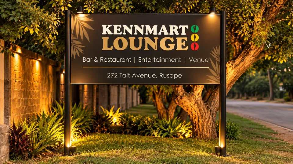 The illuminated Kennmart Lounge entrance sign surrounded by greenery
